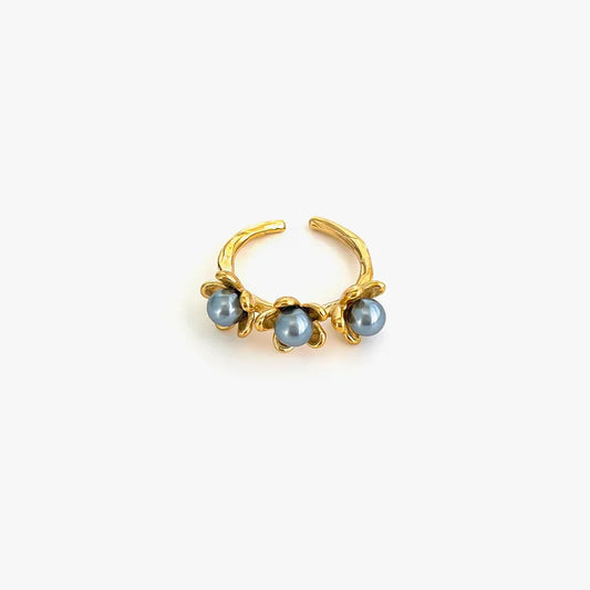 Gold nose ring with three blue gemstones on a white background
