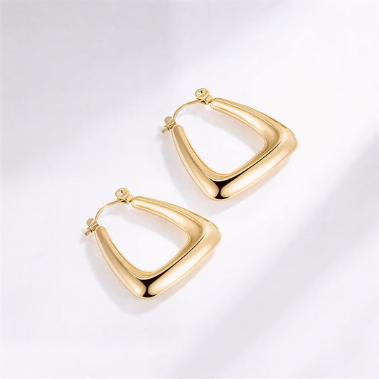 Gold hoop earrings on a light gray background