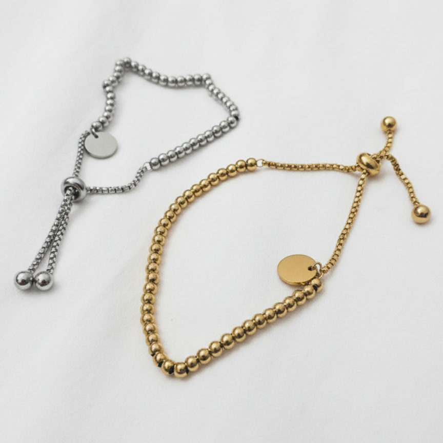 Gold and silver beaded bracelets on a light gray background