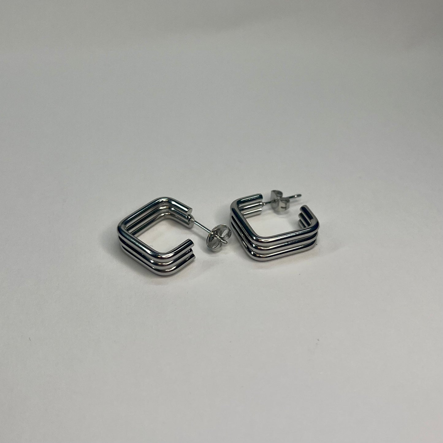 Pair of silver hoop earrings on a light gray background