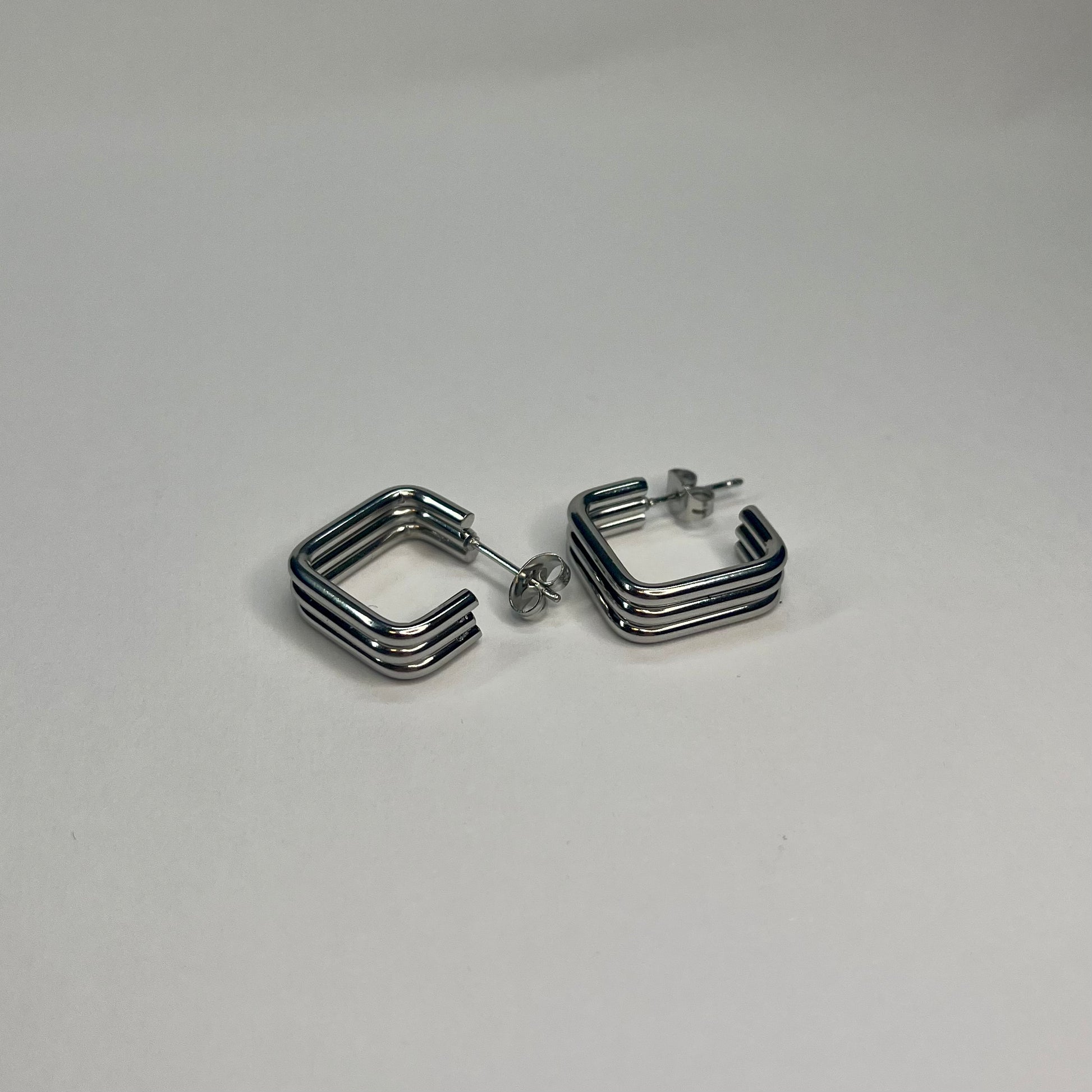 Pair of silver hoop earrings on a light gray background