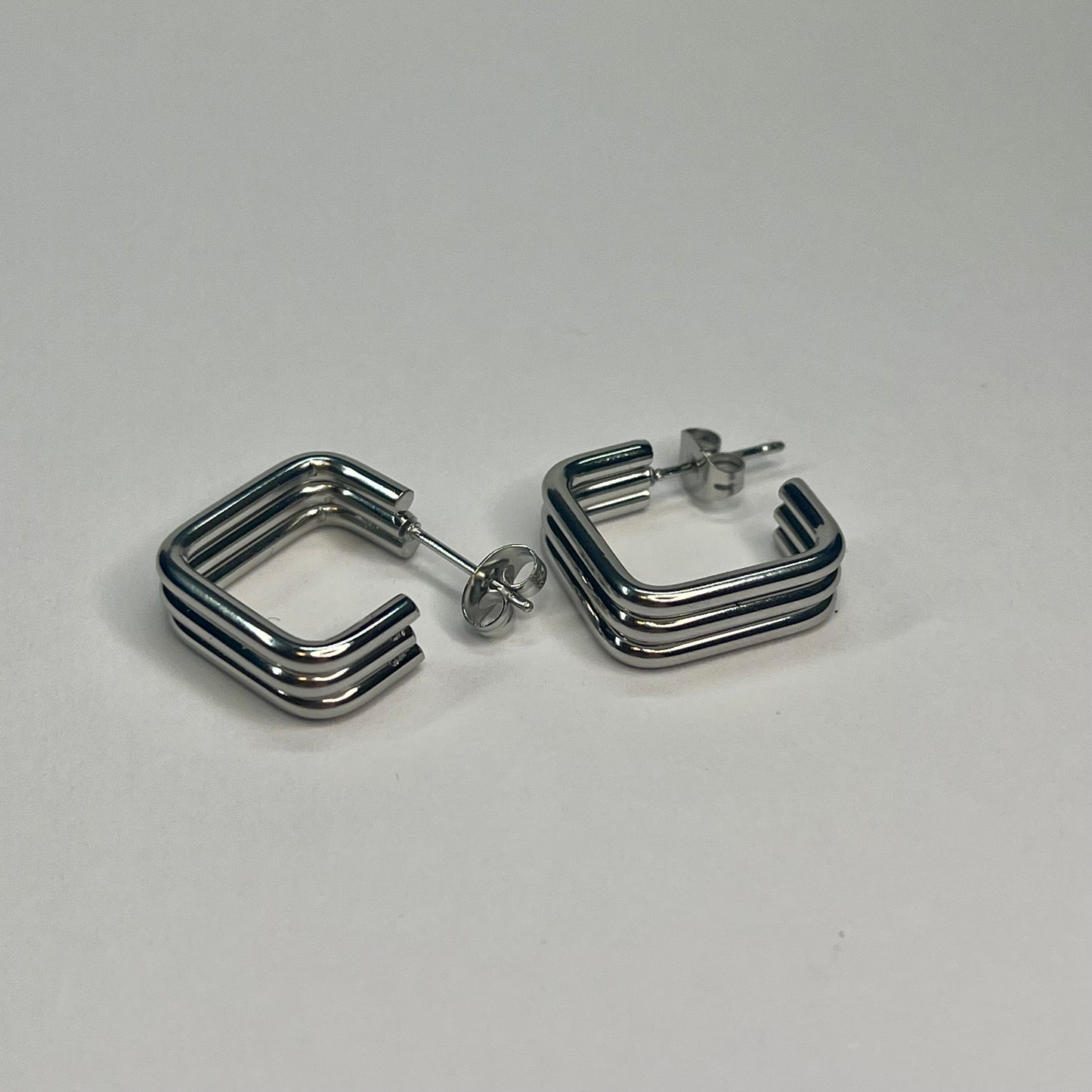 Pair of silver hoop earrings on a light gray background