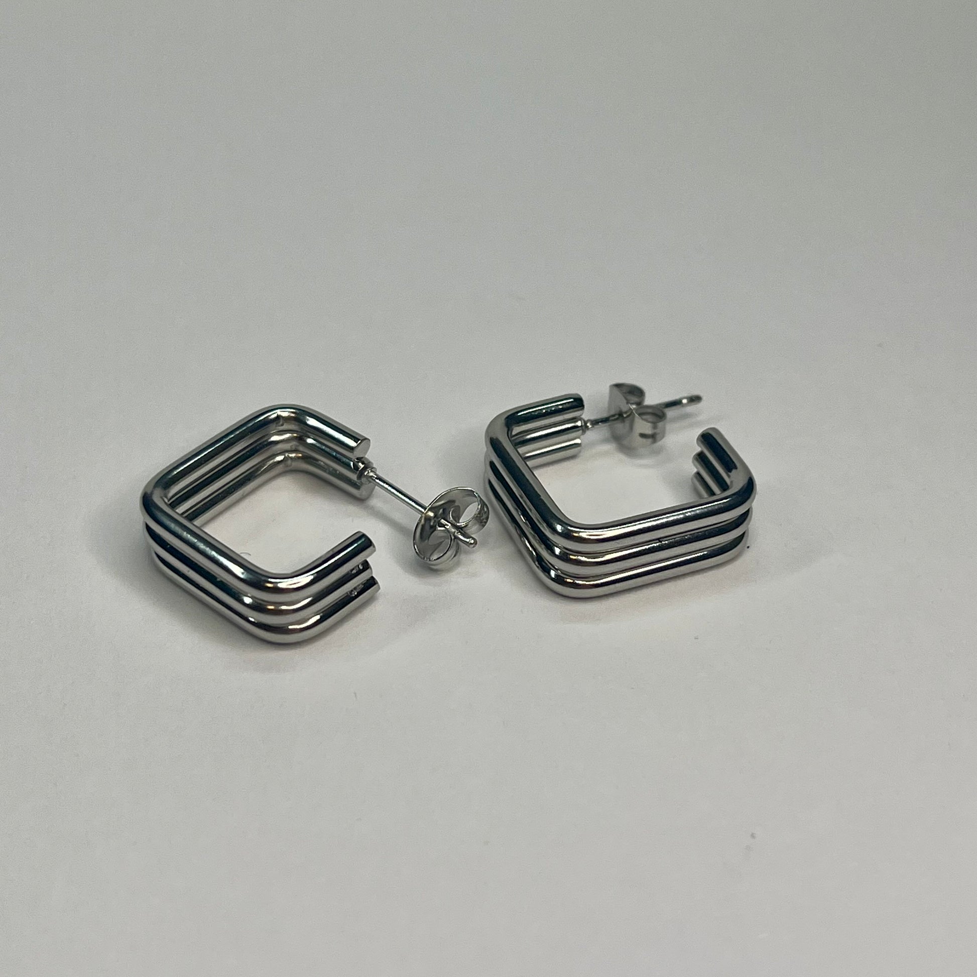 Pair of silver hoop earrings on a light gray background