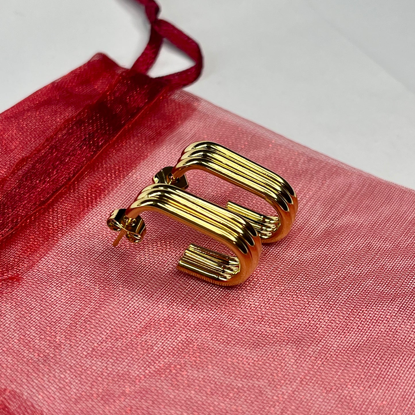 Gold earring on a red fabric background