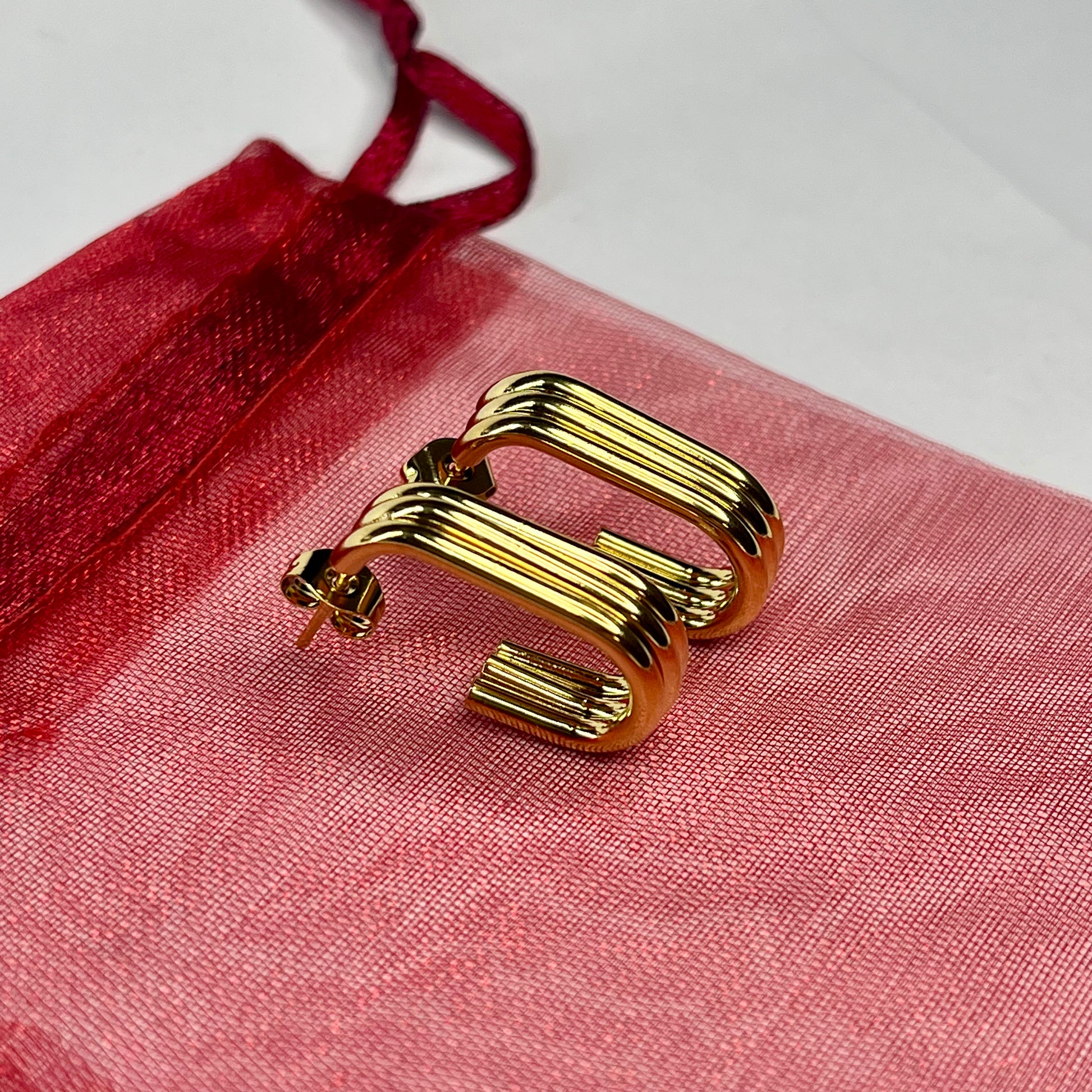 Gold earring on a red fabric background