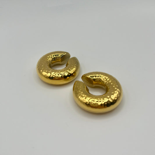 Pair of gold hoop earrings on a light gray background