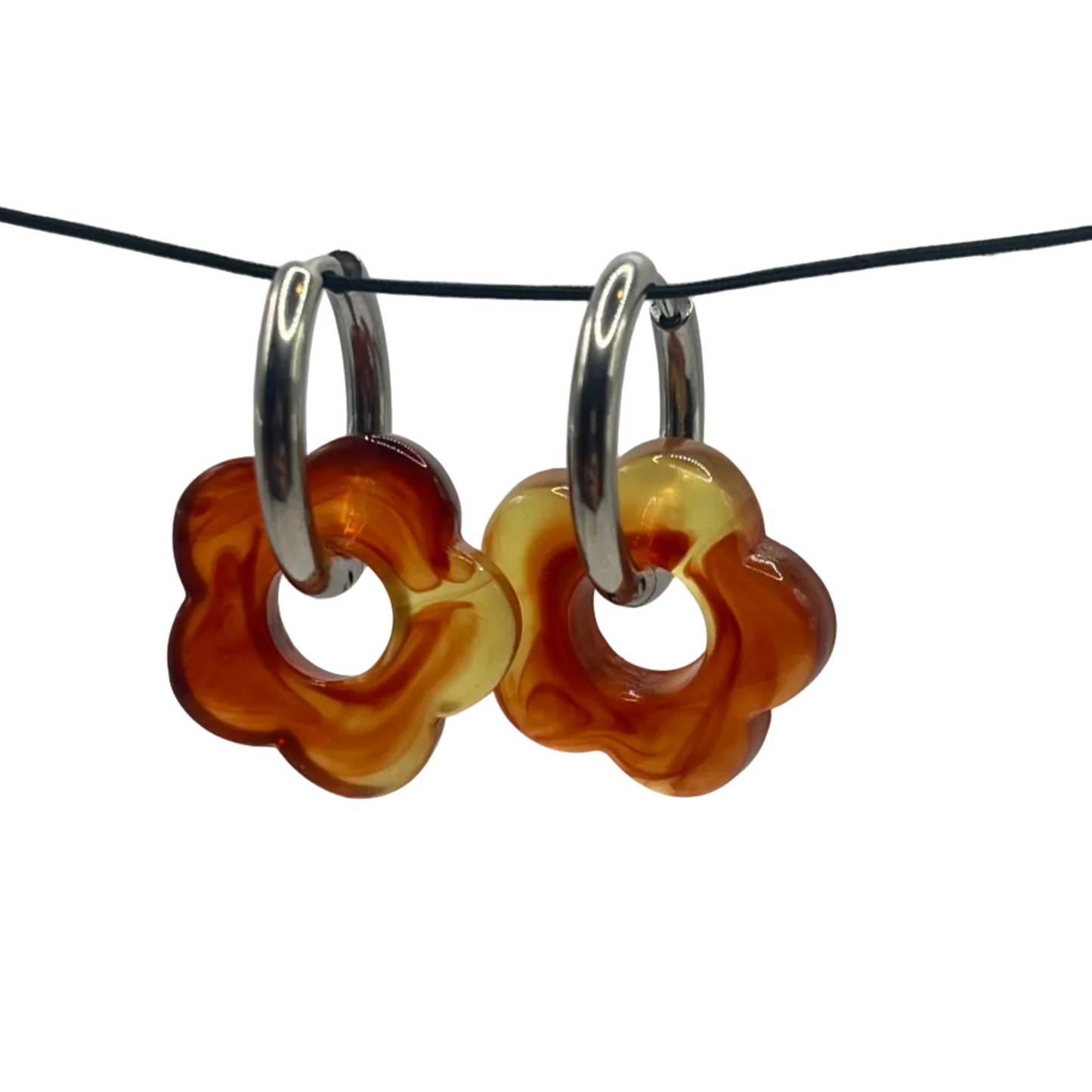 Pair of glass flower-shaped earrings on a black cord against a white background