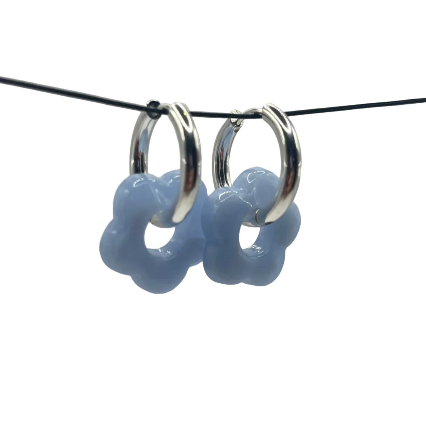Silver hoop earrings with blue connectors on a black cord against a gray background