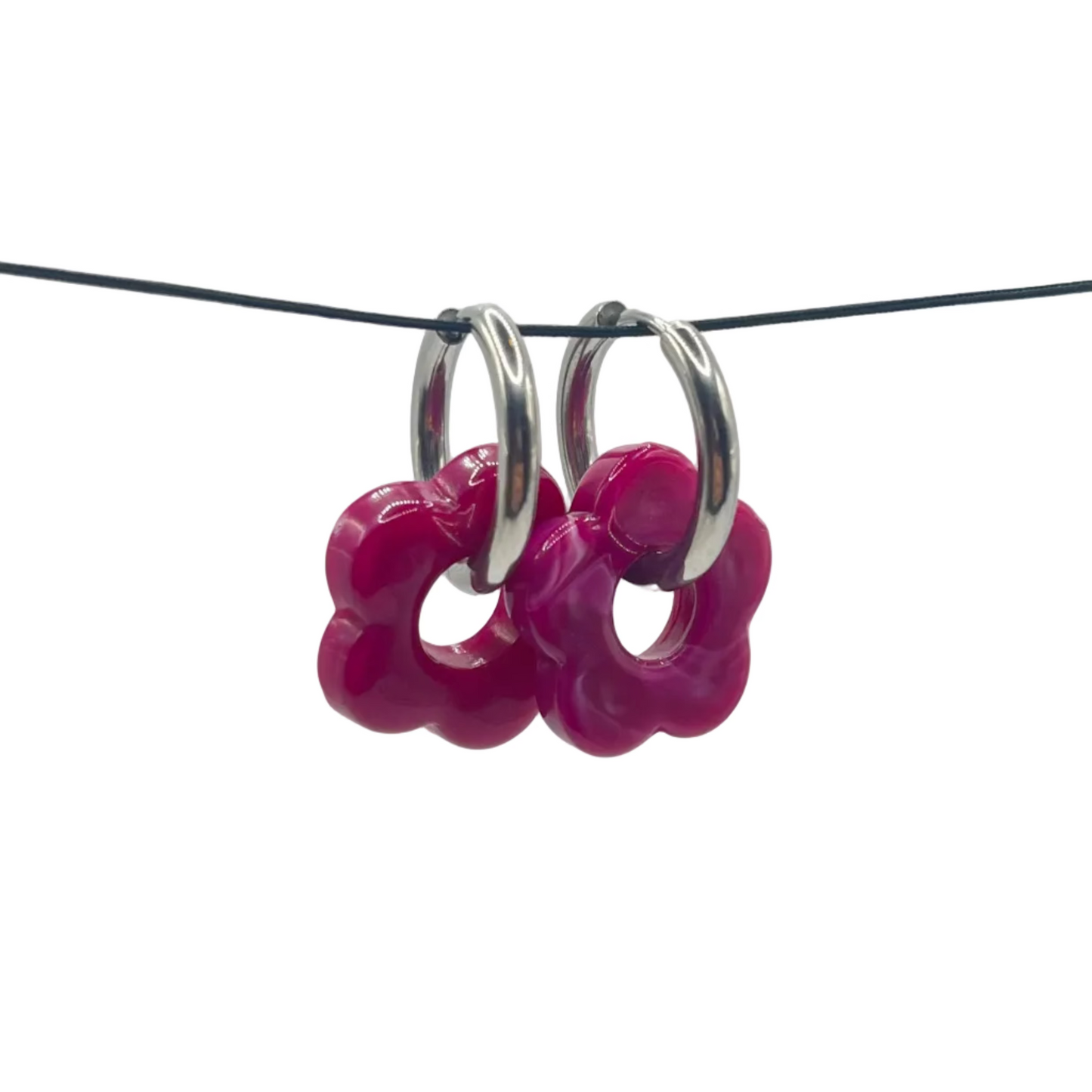 Pink hoop earrings on a thin black wire against a light gray background