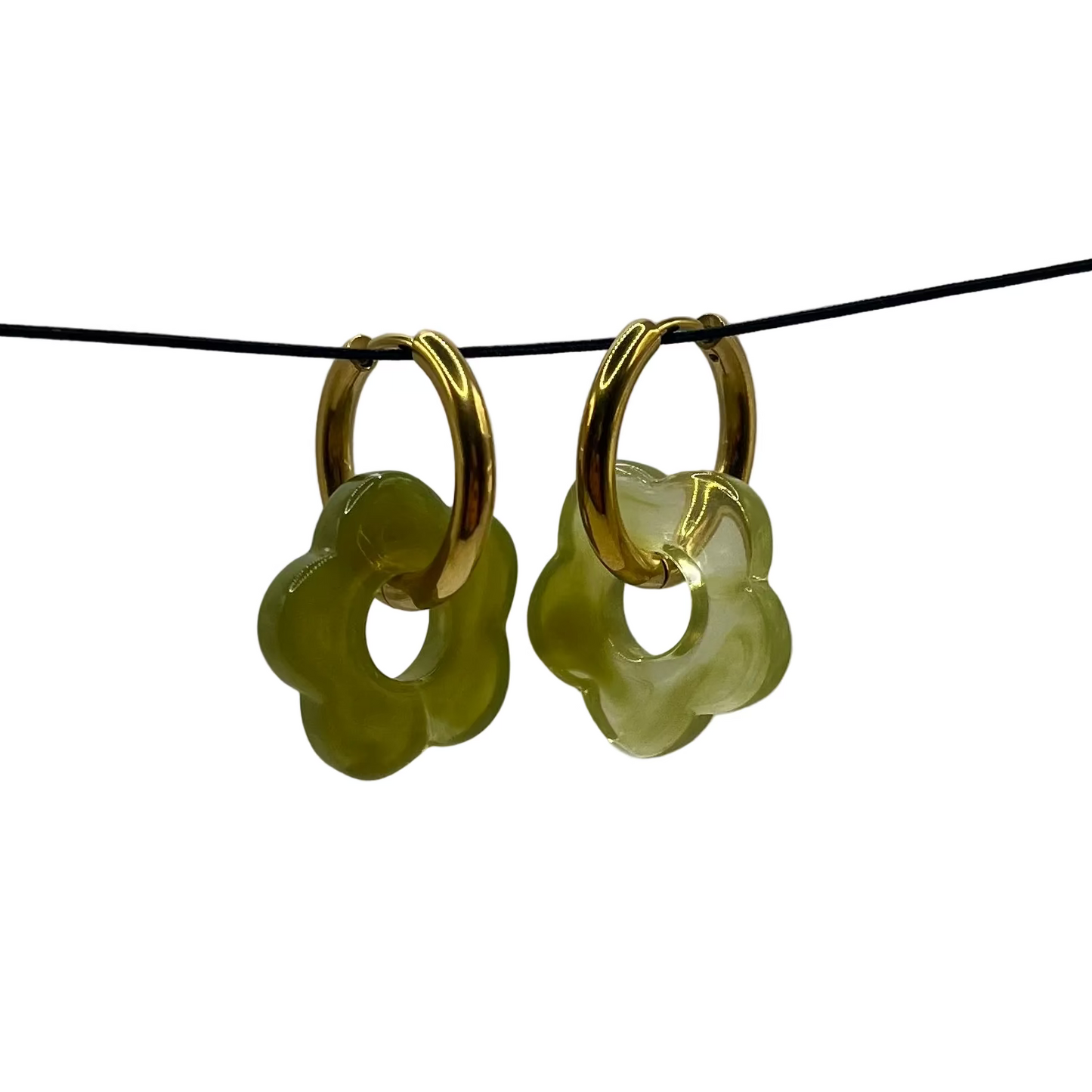 Gold hoop earrings with green circular charms on a thin black wire against a gray background