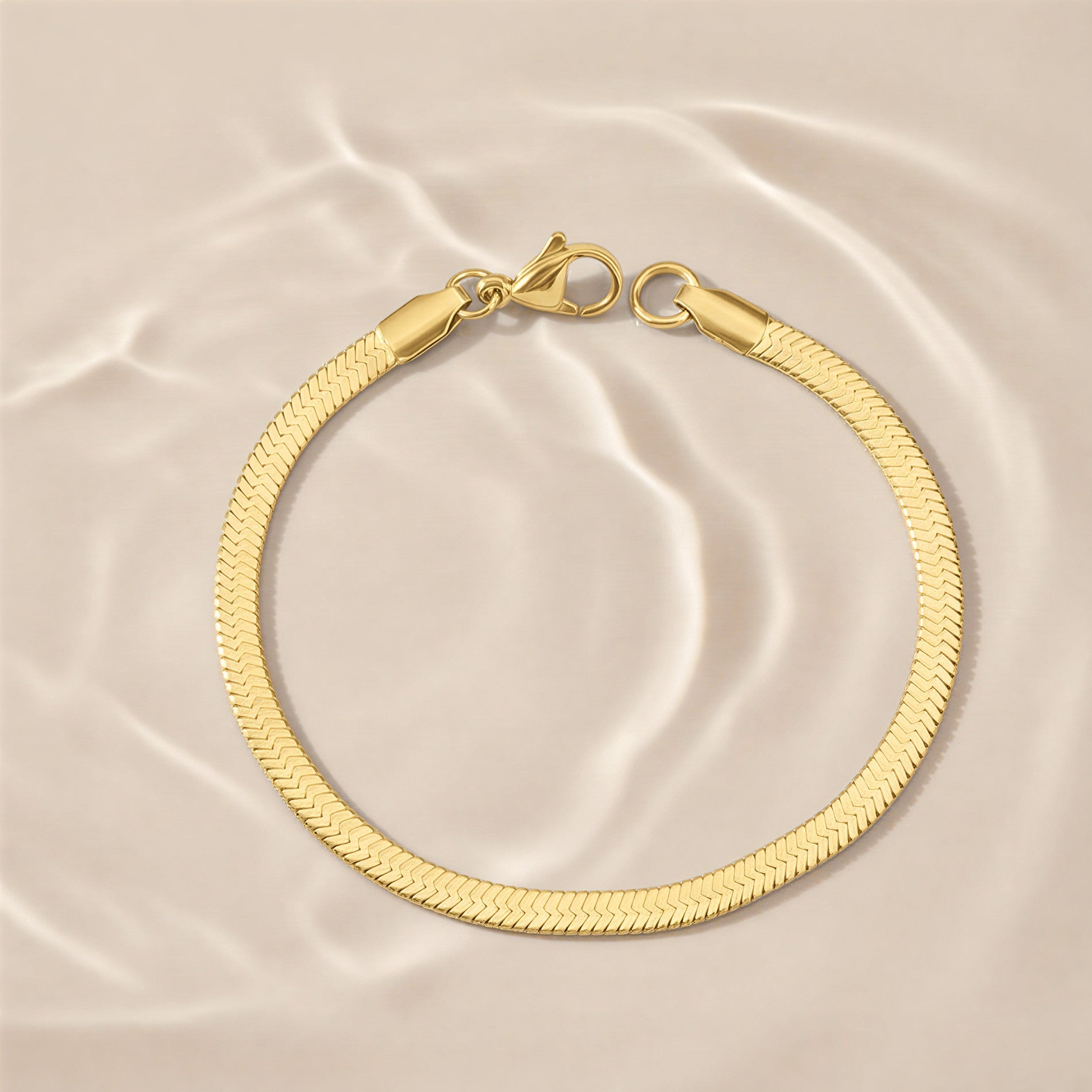 Gold bracelet on a beige satin background