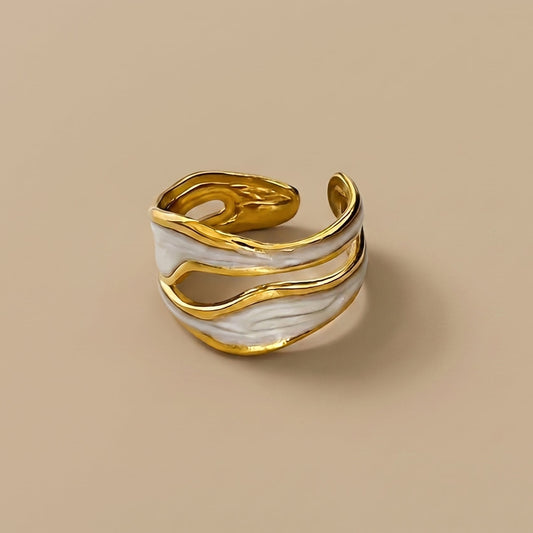 Gold and white marbled ring on a beige background with 'NORU' branding.