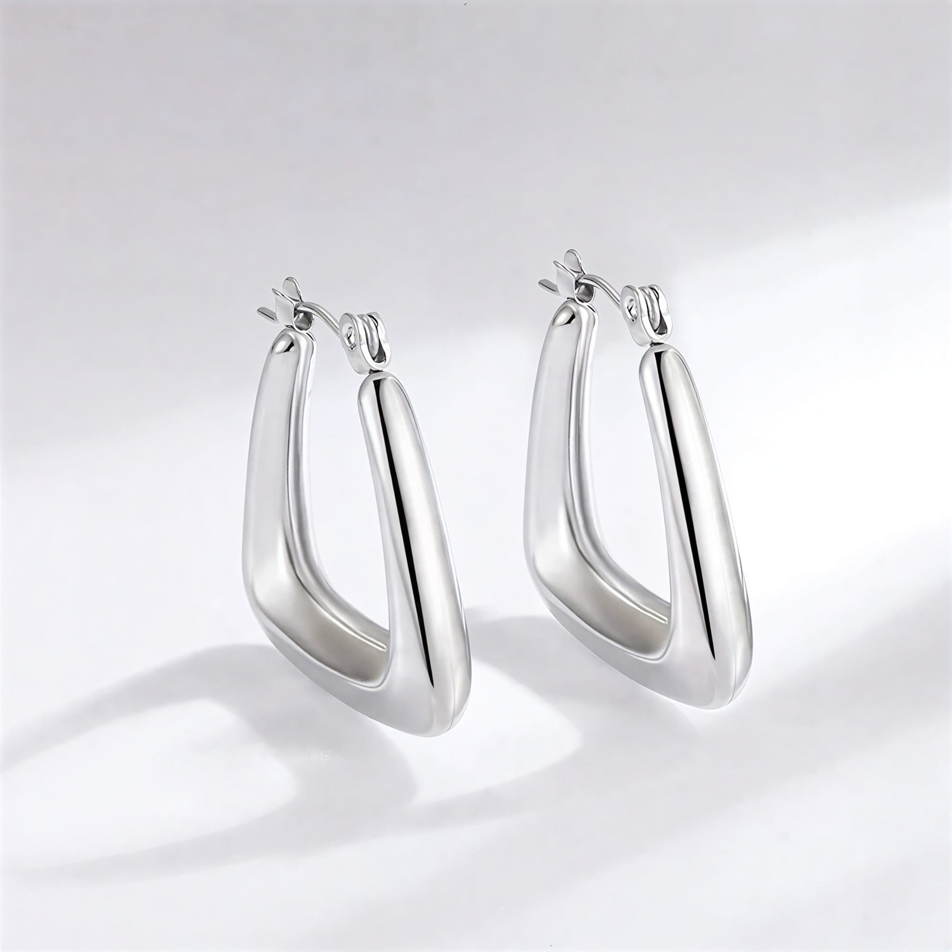 Pair of silver hoop earrings on a light gray background