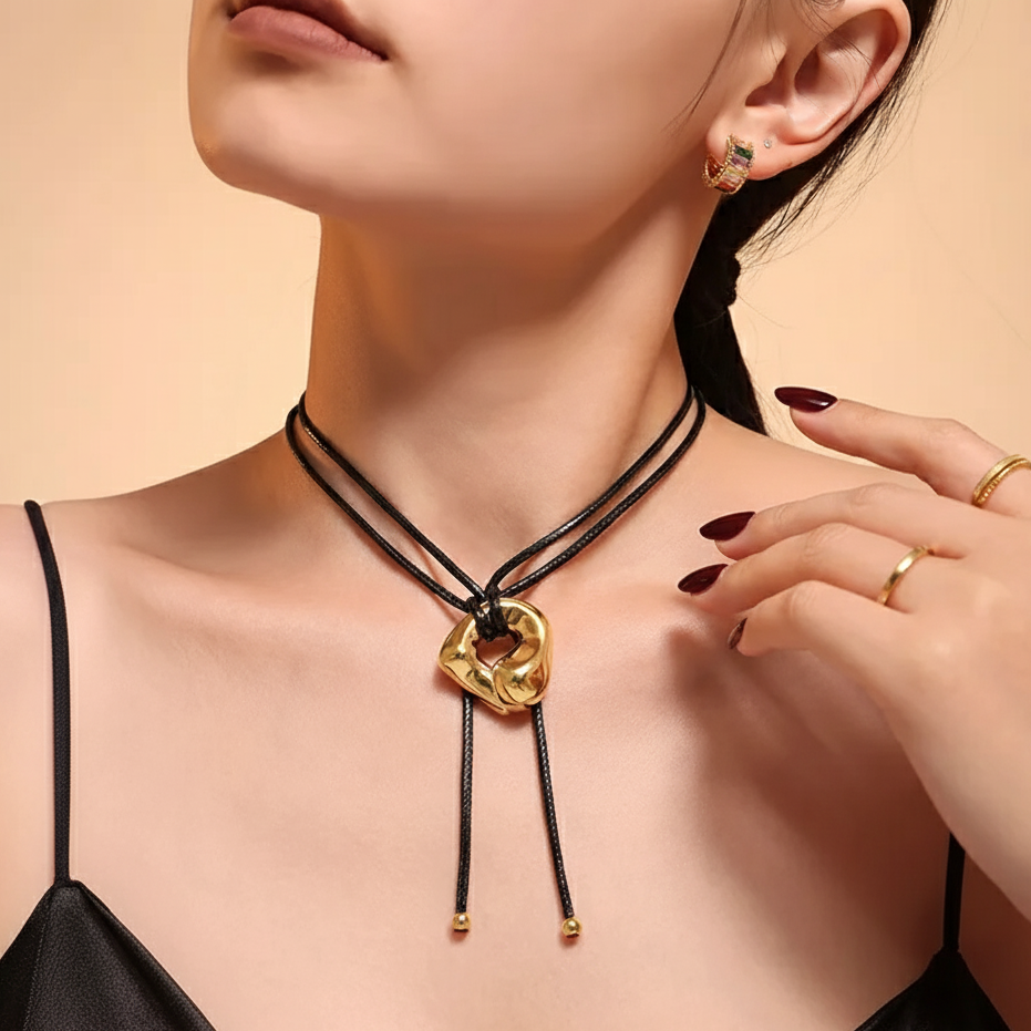 Woman wearing a gold necklace and earrings on a beige background