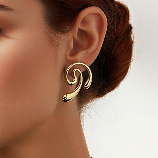 Woman wearing a gold earring against a plain background