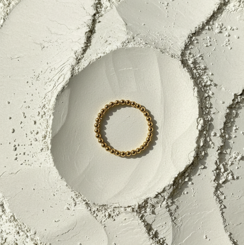Gold ring on a textured white surface