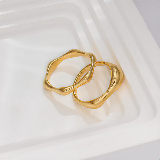 Two gold rings on a white fabric background