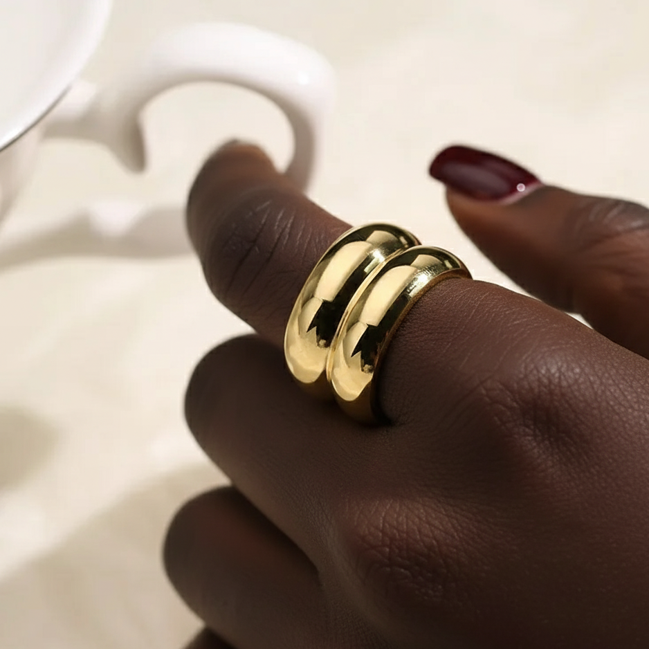 Gold ring on a person's finger with a blurred background