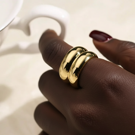 Gold ring on a person's finger with a blurred background